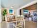 Open dining area with a hardwood table, white chairs, and beachy accents is adjacent to a living room with a fireplace at 1604 Casey Key Rd, Nokomis, FL 34275