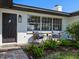 Charming home exterior with cozy seating area and well-manicured landscaping at 1604 Casey Key Rd, Nokomis, FL 34275