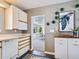 Bright kitchen featuring white cabinets and an adjacent dining area at 1604 Casey Key Rd, Nokomis, FL 34275