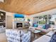 Comfortable living room with wood-paneled ceiling, fireplace, and water view at 1604 Casey Key Rd, Nokomis, FL 34275