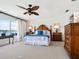 Bright main bedroom featuring a water view, wooden furniture, and ceiling fan at 1604 Casey Key Rd, Nokomis, FL 34275