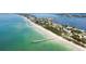 Stunning aerial shot of the coastline, showcasing the beautiful beach, docks and charming waterfront homes at 1871 Bridge St, Englewood, FL 34223