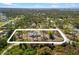 Aerial view of the property with a white boundary line in a lush, wooded area with nearby water at 1871 Bridge St, Englewood, FL 34223