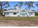 Charming home featuring a bright white exterior, light roof, and light blue double doors at 1871 Bridge St, Englewood, FL 34223