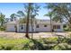 Home's white exterior featuring a bright exterior, light roof, and blue double doors at 1871 Bridge St, Englewood, FL 34223