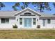 Home's front exterior featuring blue double doors, white facade, and a light-colored roof at 1871 Bridge St, Englewood, FL 34223