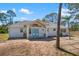 Charming home featuring a bright white exterior, light-colored roof, and light blue double doors at 1871 Bridge St, Englewood, FL 34223