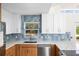 Modern kitchen boasts stainless steel appliances, blue backsplash, and ample counter space under natural light at 1871 Bridge St, Englewood, FL 34223