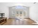 A bright living room features wood-look flooring, neutral walls, and french doors leading to the outside at 1871 Bridge St, Englewood, FL 34223