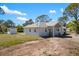 Rear exterior view of the home, featuring a bright white exterior, light roof, and ample yard space at 1871 Bridge St, Englewood, FL 34223