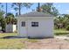 Exterior view of a small, white, block-construction shed with a door, window and concrete pad at 1871 Bridge St, Englewood, FL 34223