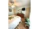 Cozy bedroom with light green walls, wood-look flooring, a ceiling fan and a TV at 199 Palm Harbor Dr, North Port, FL 34287