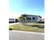Cozy gray home surrounded by manicured lawn and picturesque palm trees at 199 Palm Harbor Dr, North Port, FL 34287