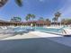 Community swimming pool surrounded by palm trees and lounge chairs, ideal for residents to relax and enjoy the sunny weather at 199 Palm Harbor Dr, North Port, FL 34287