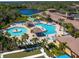 Aerial view of community pool and clubhouse, with ample seating and lake views at 20390 Cavallo Ct, Venice, FL 34292