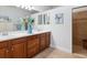 Bathroom featuring double sinks with quartz countertops, wood cabinets, and a tile floor at 20390 Cavallo Ct, Venice, FL 34292