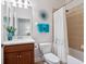 Clean bathroom with a cherry wood vanity, updated lighting and a shower and tub combo at 20390 Cavallo Ct, Venice, FL 34292