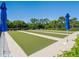 Well-maintained bocce ball court with lush green turf, bordered by palm trees and vibrant greenery at 20390 Cavallo Ct, Venice, FL 34292