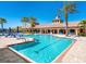 Resort-style pool area with lounge chairs and palm trees at the community clubhouse at 20390 Cavallo Ct, Venice, FL 34292
