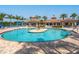 Large community pool with a center island and seating, surrounded by palm trees at 20390 Cavallo Ct, Venice, FL 34292