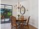 Elegant dining area with a stylish chandelier, round wood table, and views of the screened patio at 20390 Cavallo Ct, Venice, FL 34292