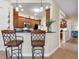 Kitchen bar with granite countertops, wooden cabinets, pendant lighting, and seating for casual dining at 20390 Cavallo Ct, Venice, FL 34292