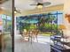 Outdoor lanai featuring a dining set, seating area, ceiling fans, and views of the lush greenery at 20390 Cavallo Ct, Venice, FL 34292