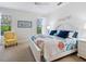 Bright bedroom boasts a floral comforter, white furniture, and natural light from the two windows at 20390 Cavallo Ct, Venice, FL 34292