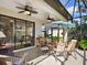 Screened patio with ceiling fans, outdoor furniture, and views to the backyard at 20390 Cavallo Ct, Venice, FL 34292