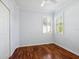 Bedroom with hardwood floors, a closet, and a window featuring white shutters at 2059 Batello Dr, Venice, FL 34292