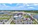 Community aerial view featuring colorful buildings, palm trees, and parking spaces under a partly cloudy blue sky at 20925 Valore Ct, Venice, FL 34293