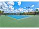 Well-maintained tennis court on a sunny day with professional lighting and green landscaping at 20925 Valore Ct, Venice, FL 34293