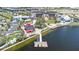 Community waterfront with dock, colorful buildings, and palm trees under a partly cloudy blue sky at 20925 Valore Ct, Venice, FL 34293