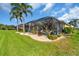 Lush backyard with tropical landscaping, a screened lanai, and beautiful outdoor living at 2172 Chenille Ct, Venice, FL 34292