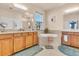 Bright bathroom with dual vanities, a soaking tub, and natural light from the window at 2172 Chenille Ct, Venice, FL 34292