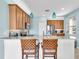 Bright kitchen boasts stone countertops, pendant lighting, stainless appliances, and wood cabinets at 2172 Chenille Ct, Venice, FL 34292