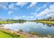 Panoramic view of a serene lake reflecting the clear blue sky with scattered clouds at 2172 Chenille Ct, Venice, FL 34292