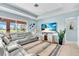 The living room features a large window, tv and cozy, gray couch at 2172 Chenille Ct, Venice, FL 34292