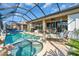 Backyard oasis with a screened pool, spa, lounge chairs, and outdoor entertaining area at 2172 Chenille Ct, Venice, FL 34292