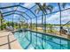 Sparkling screened-in pool with spa, comfortable lounge chairs, and peaceful lake views at 2172 Chenille Ct, Venice, FL 34292