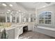 Bright bathroom featuring dual sinks, ample mirrors, garden tub and natural light at 2175 Calusa Lakes Blvd, Nokomis, FL 34275