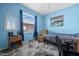 Bright blue bedroom with a cozy chair, a twin bed, and ample natural light at 2175 Calusa Lakes Blvd, Nokomis, FL 34275