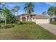 Charming single-story home with a lush green lawn, mature trees, and well-maintained landscaping at 2175 Calusa Lakes Blvd, Nokomis, FL 34275