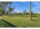 Scenic view of a lush green golf course lined with mature trees and clear blue skies on a sunny day at 2175 Calusa Lakes Blvd, Nokomis, FL 34275