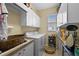 Practical laundry room with white cabinetry, washer, dryer, and a utility sink at 2175 Calusa Lakes Blvd, Nokomis, FL 34275