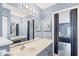 Well-lit bathroom featuring blue accents, double mirrors, vanities, and decorative lighting at 221 Mark Twain Ln, Rotonda West, FL 33947