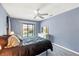 Bedroom with blue walls, fan, and sliding glass door with a view of the pool at 221 Mark Twain Ln, Rotonda West, FL 33947