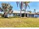 Charming single-story home featuring a well-maintained lawn and mature palm trees in a serene neighborhood at 221 Mark Twain Ln, Rotonda West, FL 33947
