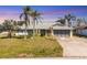 Charming single-story home featuring a well-maintained lawn and mature palm trees in a serene neighborhood at 221 Mark Twain Ln, Rotonda West, FL 33947