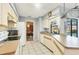 Well-lit kitchen featuring tile floors, ample countertop space, and convenient access to the dining area at 221 Mark Twain Ln, Rotonda West, FL 33947